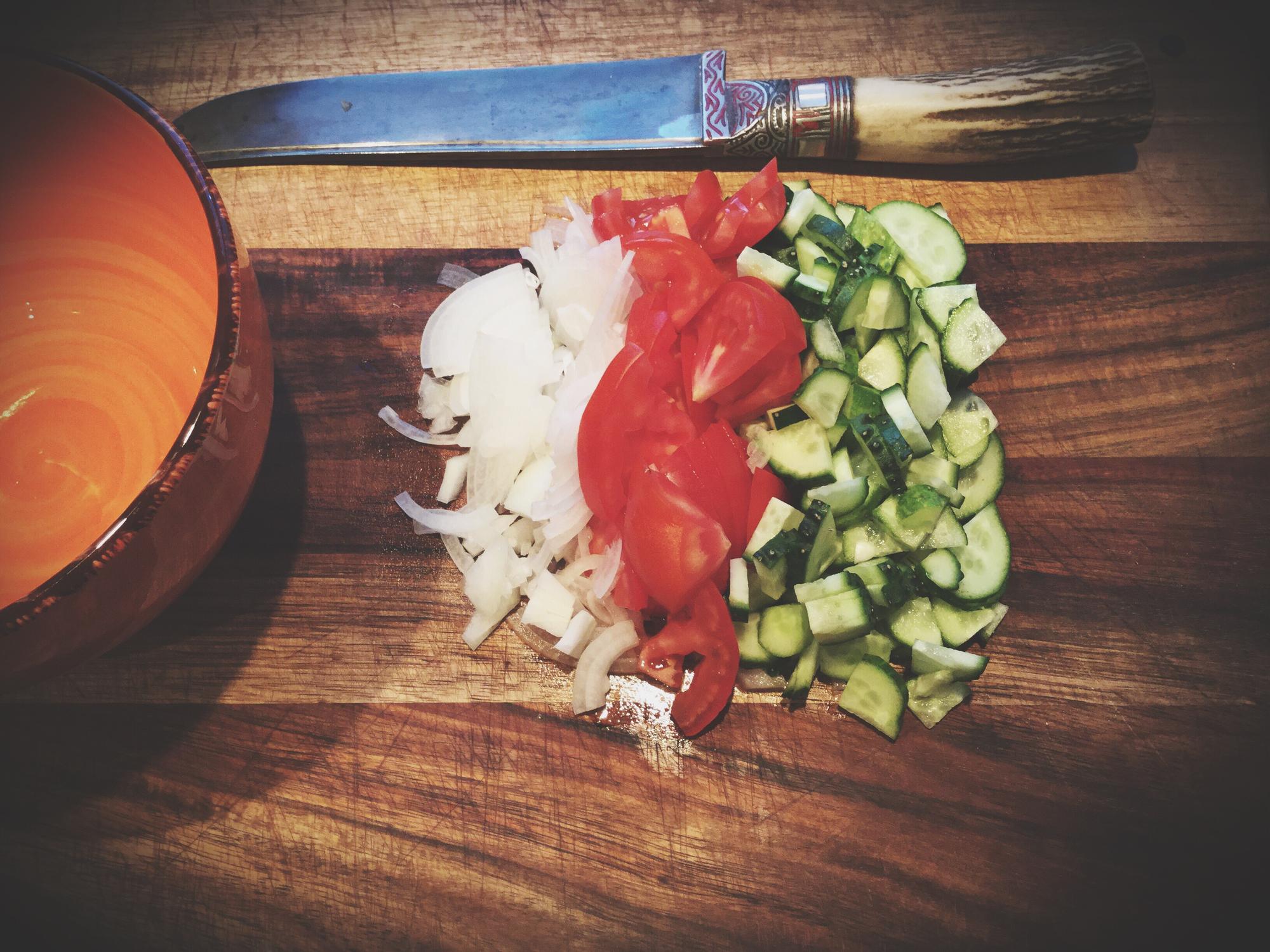 Detailed shot of hand-held mandoline and sliced vegetables